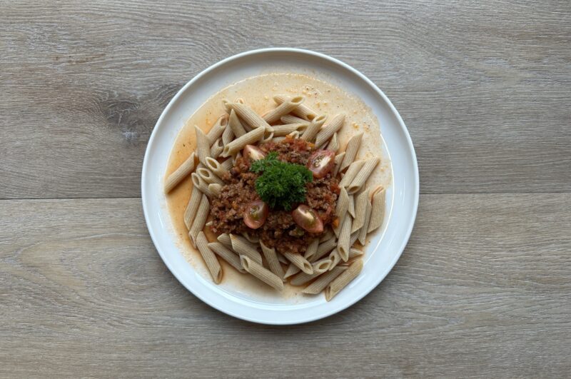 Bilete visar kvit fat med pasta og tomatsaus m/kjøttdeig ,pyntet med tomater og persilledusk.