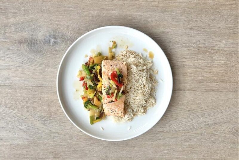 Kvit fat med ovnsbakt laksefilet med wokgrønsaker og ris