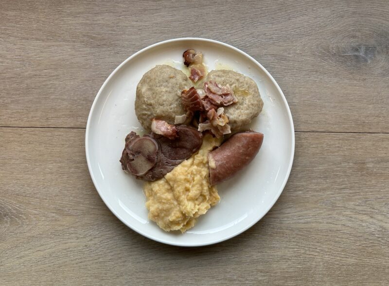 Bilete viser eit kvit fat med raspekaker, røykt kjøt. korv , bacon og kålrotstappe