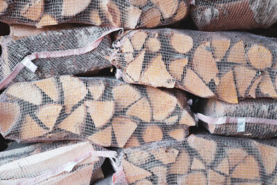 Stabel med bjørkeved, pakka i sekkar.